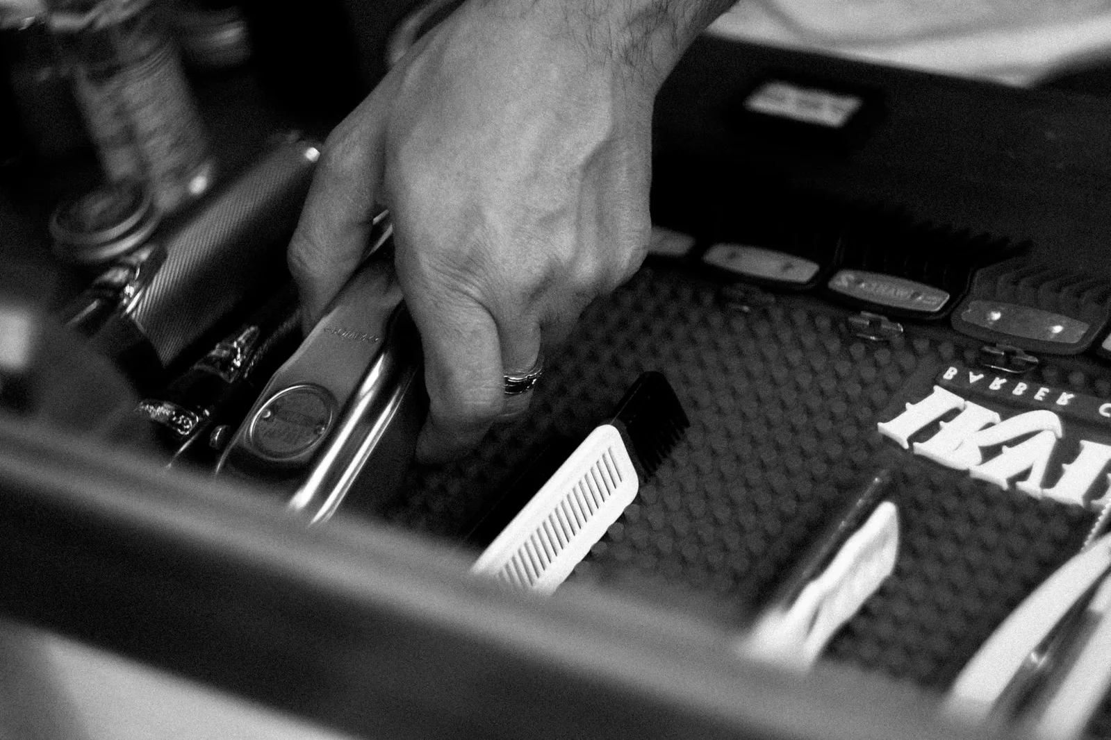 Representative monochrome view of barber tools being arranged on a tray